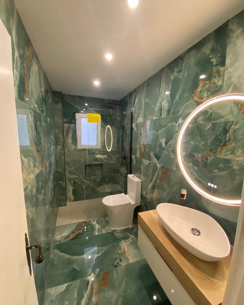 Baño reformado con revestimiento tipo ónice verde por AARSTEK